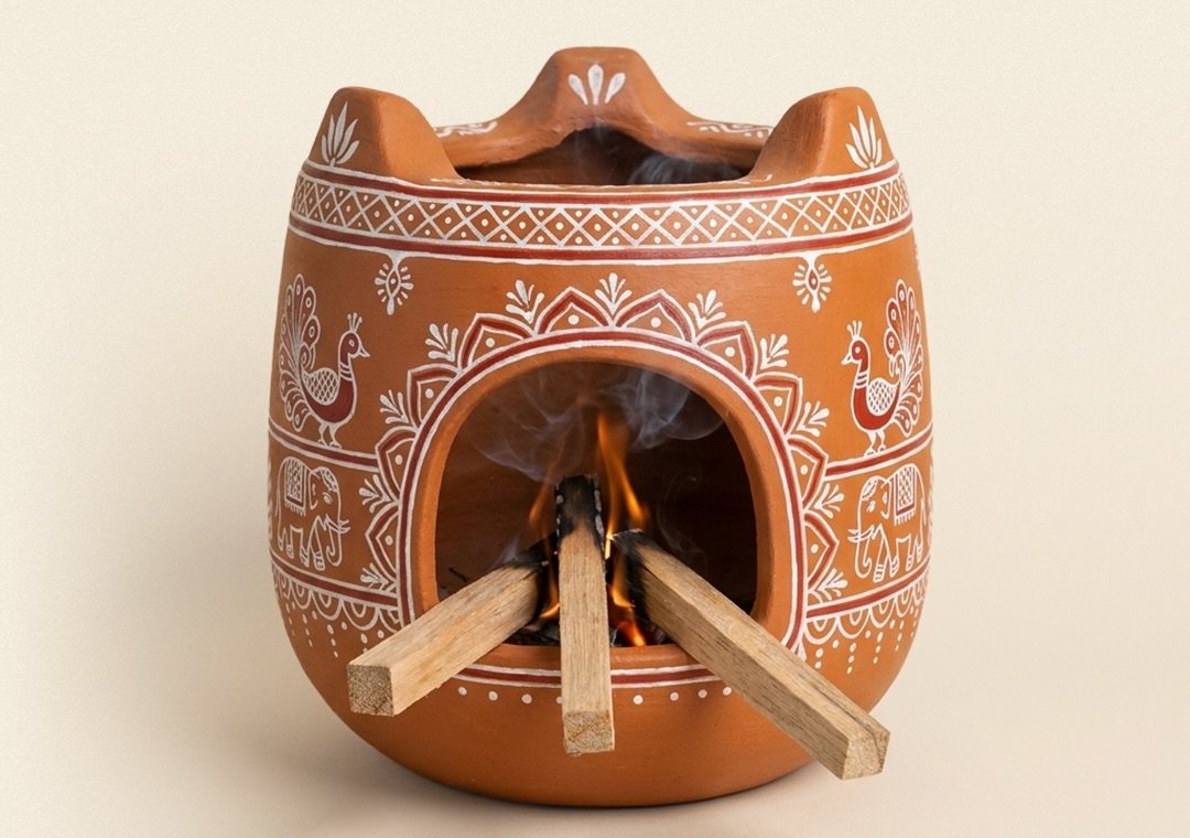 A hand-painted clay stove with wood burning inside